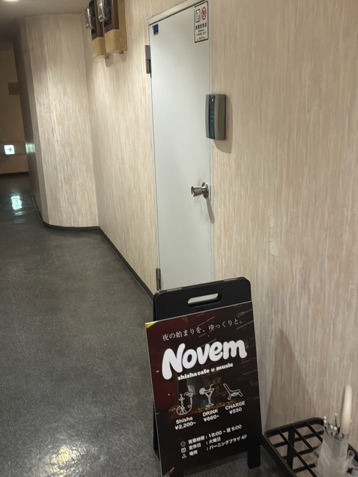 シーシャカフェ&ミュージックバー Novem の入口 — バーニングプラザ4階、白い扉と黒い立て看板
